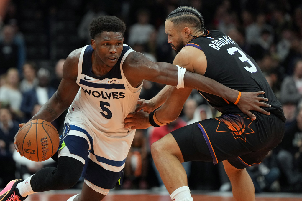 Minnesota Timberwolves guard Anthony Edwards drives past Phoenix Suns forward Dillon Brooks (3) during the second half of an NBA Cup basketball game, Friday, Nov. 21, 2025, in Phoenix. (AP Photo/Rick Scuteri)