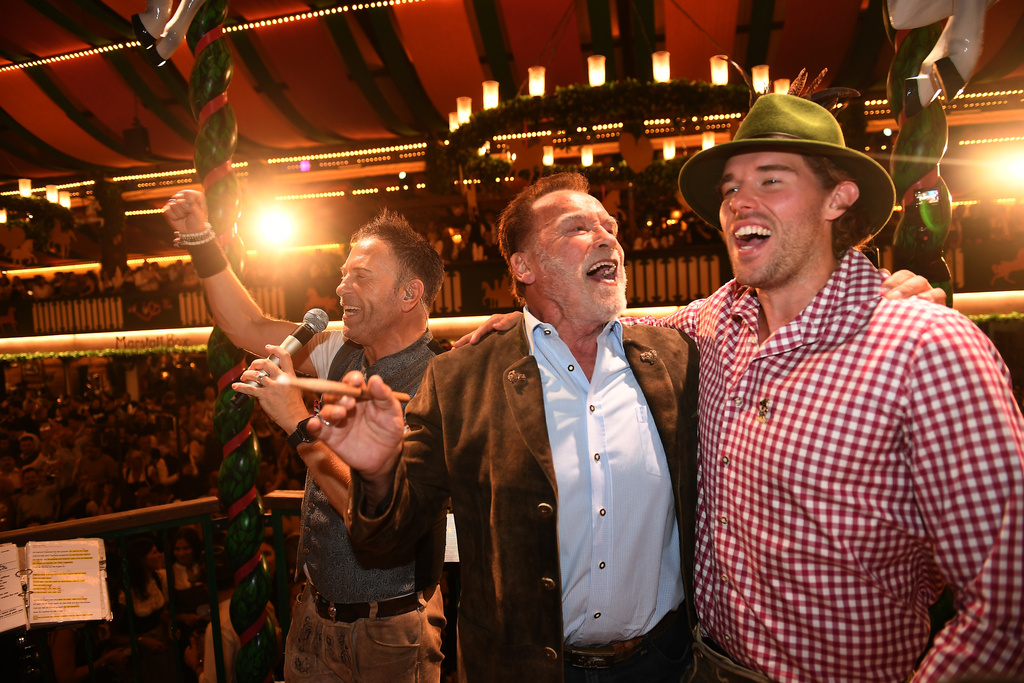 Arnold Schwarzenegger and his son, Christopher Schwarzenegger, stand on stage during the 190th Oktoberfest on Friday, Sept. 26, 2025, in Munich, Germany. (Felix Hörhager/dpa via AP)