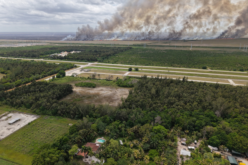 A wildfire burns Monday, May 11, 2026, in Broward County, Fla. (AP Photo/Daniel Kozin)