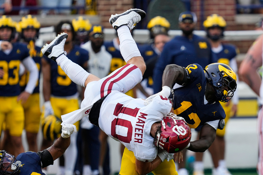 Oklahoma quarterback John Mateer (10) is tackled by Michigan linebacker Nathaniel Owusu-Boateng (12) in the second half of an NCAA college football game Saturday, Sept. 12, 2026, in Ann Arbor, Mich. (AP Photo/Paul Sancya)