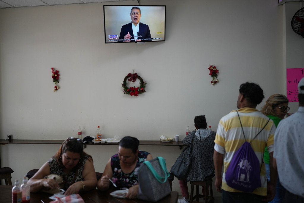 A screen shows former Honduran President Juan Orlando Hernández, who published a message on TikTok thanking U.S. President Donald Trump for pardoning him, at a coffee shop in Tegucigalpa, Honduras, Friday, Dec. 5, 2025. (AP Photo/Moises Castillo)