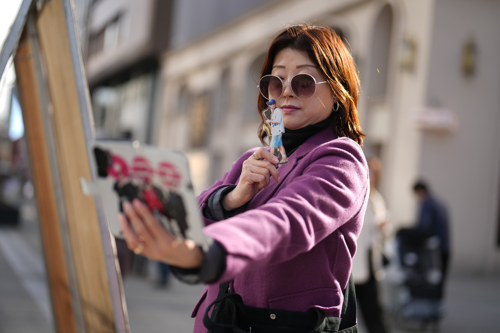A fan of K-pop band BTS takes a selfie in downtown Seoul, South Korea, Thursday, March 19, 2026. (AP Photo/Lee Jin-man)