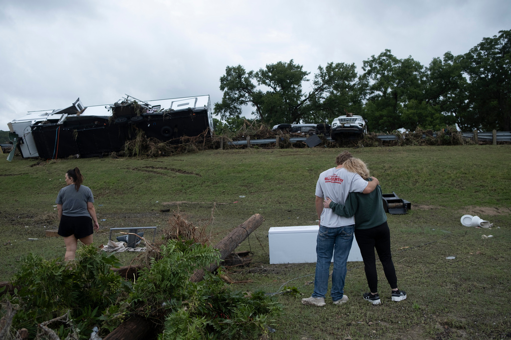 Ryder Wade is comforted by his mother Crystal Wade as they assess flood debris and damage scattered across the Buckhorn Lake Resort RV Park following floods along West Goat Creek near the Guadalupe River on Friday, July 17, 2026, in Kerrville, Texas. (AP Photo/Joel Angel Juarez)