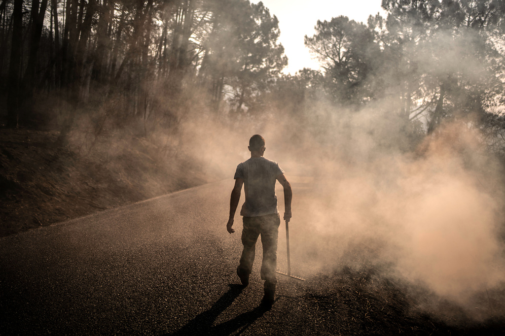A man works to extinguish hot spots in an area burned by a wildfire near Casavieja, Ávila province, Spain, Wednesday, July 29, 2026. (AP Photo/Olmo Calvo)