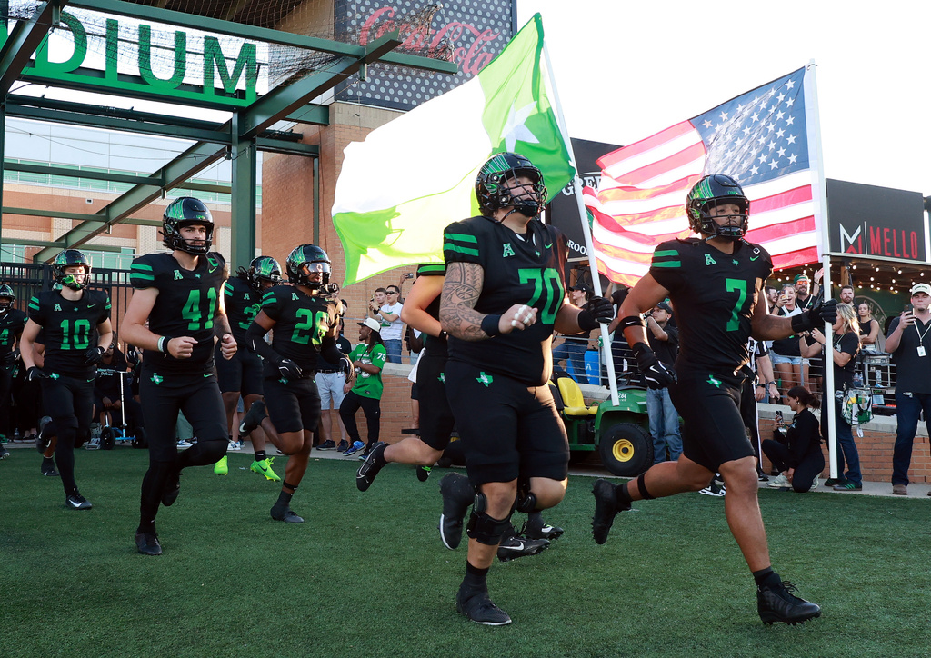 FILE - North Texas offensive lineman Tay Yanta II (70) and North Texas linebacker Shane Whitter (7) lead the team onto the field before an NCAA college football game against South Florida Oct. 10, 2025, in Denton, Texas. (AP Photo/Richard W. Rodriguez, File)