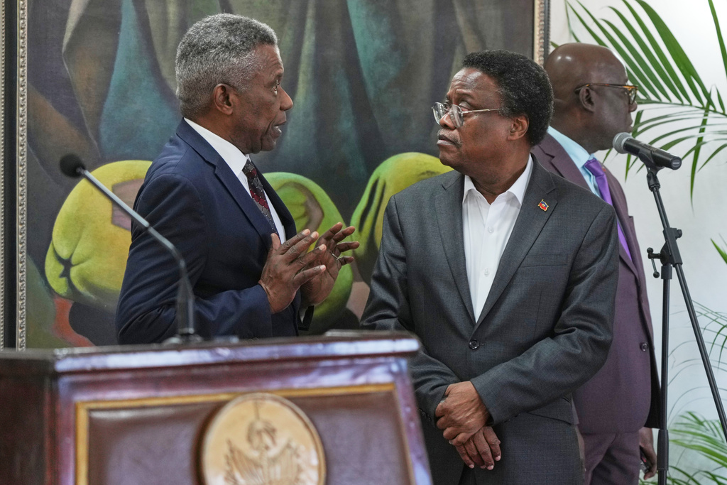Chief of Protocol of the National Palace Marc Marie Yves Mazile speaks to Fritz Alphonse Jean, a member of Haiti’s transitional presidential council, before the start of a press conference in Port-au-Prince, Haiti, Tuesday, Nov. 25, 2025. (AP Photo/Odelyn Joseph)