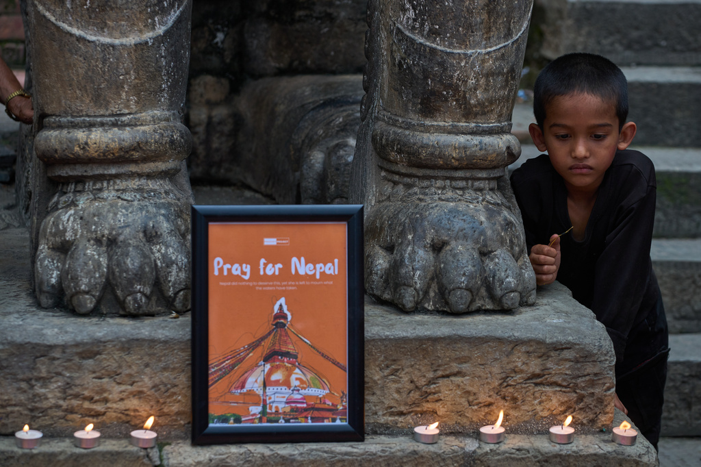 A young Nepali boy watches as people light candles during a candlelight vigil for victims of the floods in Nepal and Tibet, at Durbar Square in Kathmandu, Nepal, Saturday, Sept. 5, 2026. (AP Photo/Dar Yasin)