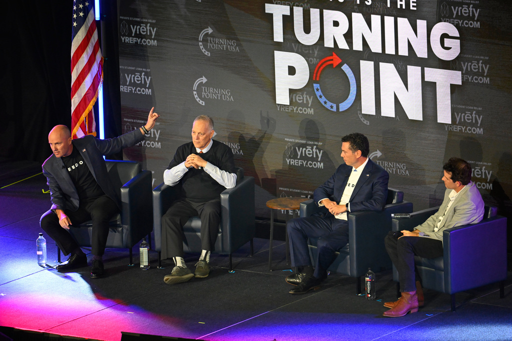 From left, Gov. Spencer Cox speaks as Rep. Andy Biggs, former Rep. Jason Chaffetz and Turning Point's Tyler Bowyer listen on stage during a Turning Point USA rally at Utah State University, as a part of the organization's push to memorialize Charlie Kirk, Tuesday, Sept. 30, 2025, in Logan, Utah. (AP Photo/Alex Goodlett)