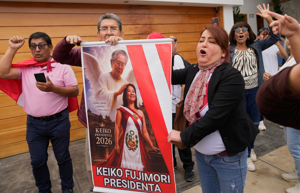 Supporters of President-elect Keiko Fujimori, cheer holding a poster depicting her with her father, former President Alberto Fujimori, outside of her home in Lima, Peru, Friday, July 3, 2026. (AP Photo/Martin Mejia)