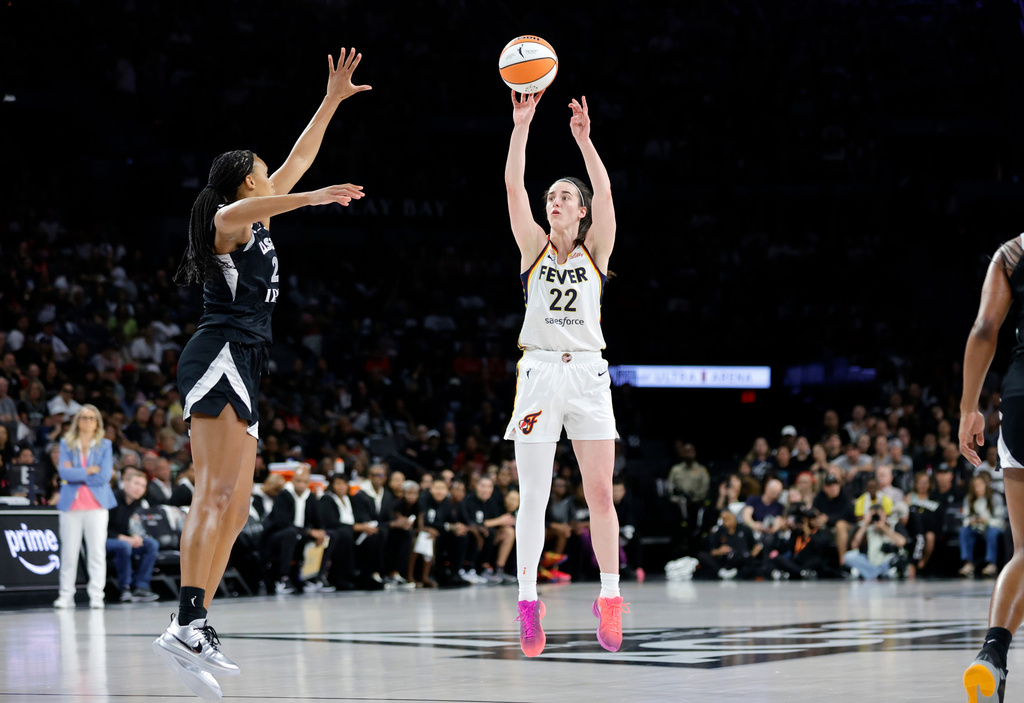 Indiana Fever guard Caitlin Clark (22) goes up to shoot a 3-point basket against Las Vegas Aces forward Brianna Turner, front left, during the first half in Game 1 of an WNBA basketball first-round playoff series Sunday, Sept. 27, 2026, in Las Vegas. (AP Photo/Steve Marcus)