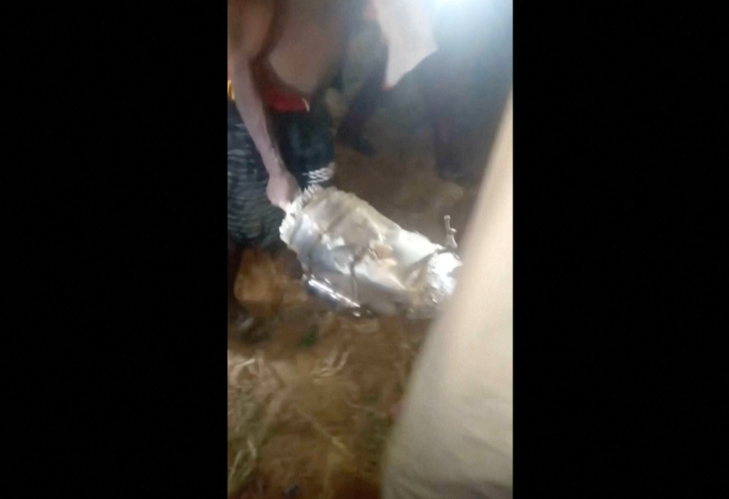 In this image made from video, local residents hold metal debris in Jabo, Nigeria, Friday, Dec. 26, 2025. (UGC via AP)
