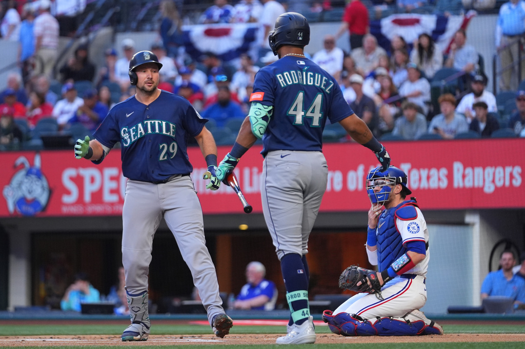 Seattle Mariners' Cal Raleigh (29) is greeted near home plate by Julio RodrÌguez (44) after hitting a solo home run off starting pitcher Jacob deGrom during the first inning of a baseball game Monday, April 6, 2026, in Arlington, Texas. (AP Photo/Julio Cortez)