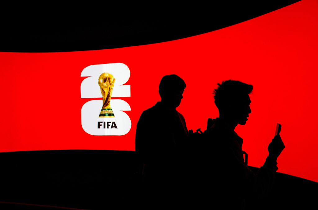 People are silhouetted against a video screen during the launch of the FIFA World Cup trophy tour in Vancouver, on Friday, April 10, 2026. (Darryl Dyck/The Canadian Press via AP)