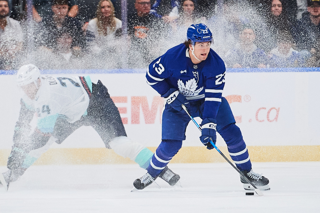 Toronto Maple Leafs' Matthew Knies (23) breaks away from Seattle Kraken's Jamie Oleksiak (24) during third period of an NHL hockey game in Toronto on Saturday, Oct. 18, 2025. (Sammy Kogan/The Canadian Press via AP)