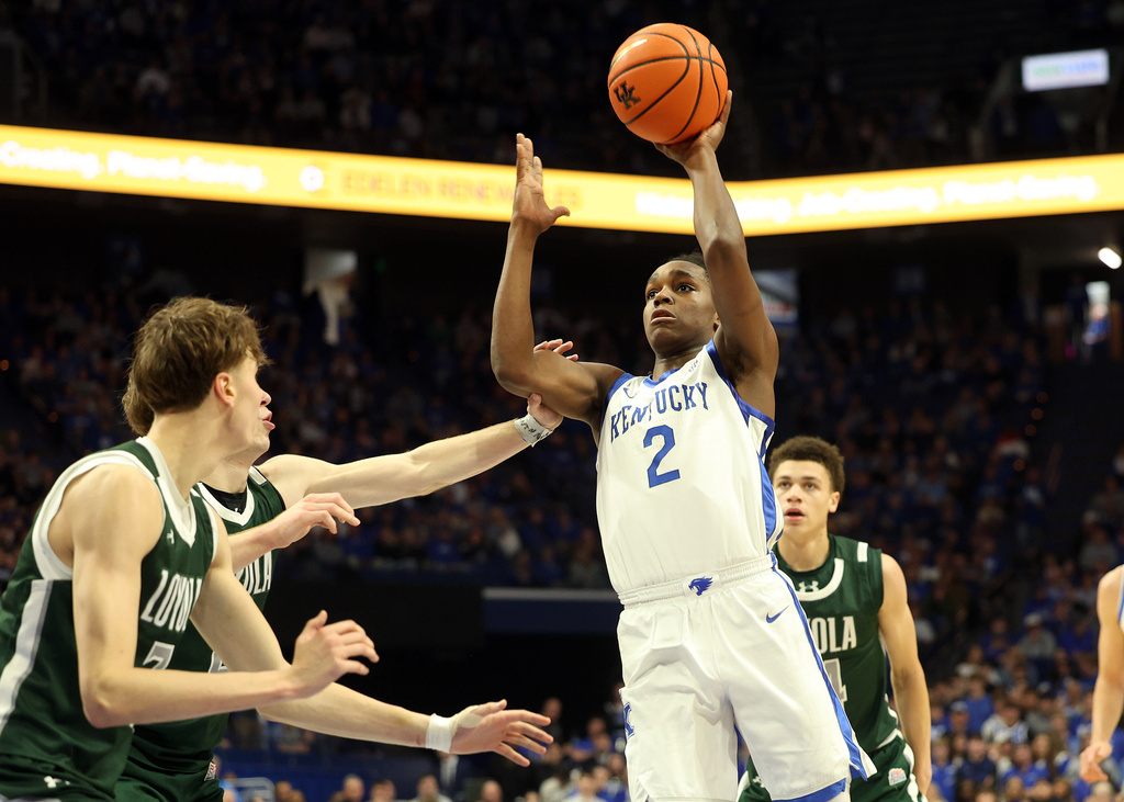 Kentucky's Jasper Johnson (2) looks to shoot while defended by Loyola-Maryland's Jonas Sirtautas, left, and Jacob Theodosiou during the first half of an NCAA college basketball game in Lexington, Ky., Friday, Nov. 21, 2025. (AP Photo/James Crisp)