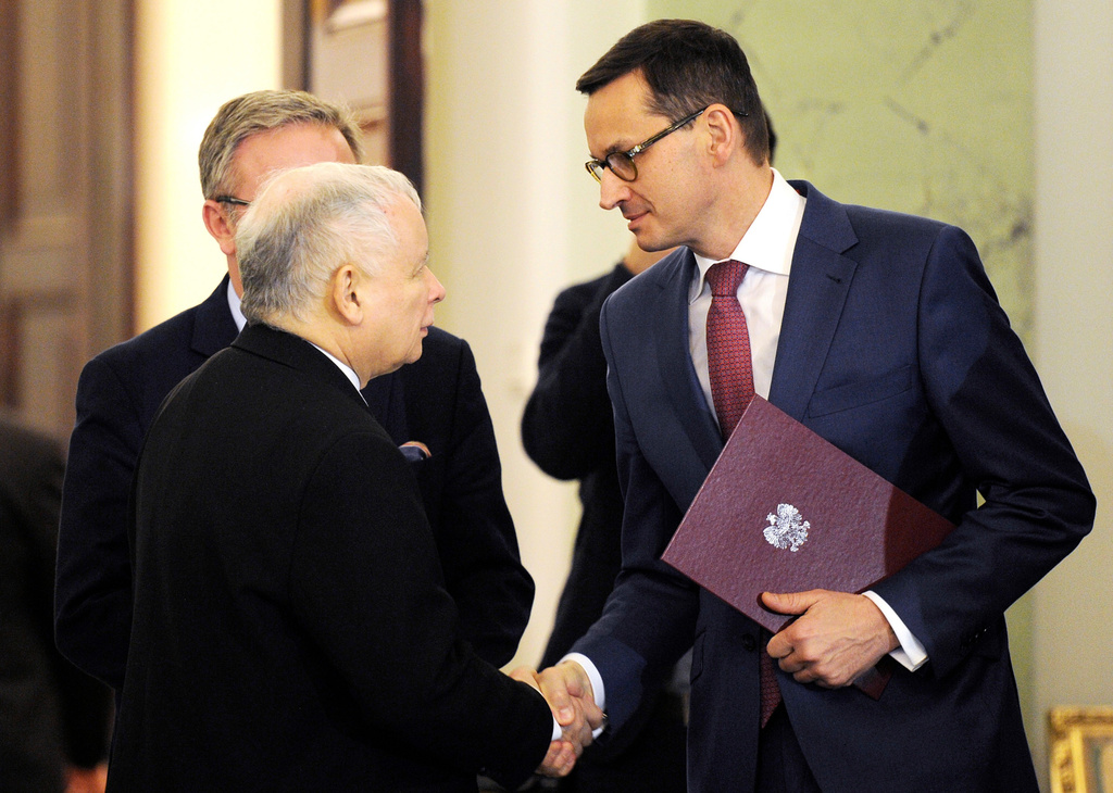 FILE - Newly designated for the prime minister's post Mateusz Morawiecki, right, is congratulated by Jaroslaw Kaczynski, left, leader of Poland's ruling conservative party Law and Justice, in Warsaw, Poland, Friday, Dec. 8, 2017. (AP Photo/Alik Keplicz, File)
