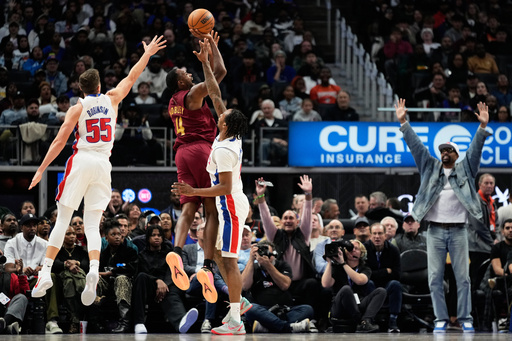 Cleveland Cavaliers center Evan Mobley, center, shoots against Detroit Pistons forward Duncan Robinson, left, and guard Ron Holland II, third from left, as former NBA player Jalen Rose, right, reacts during the first half of an NBA basketball game, Monday, Oct. 27, 2025, in Detroit. (AP Photo/Ryan Sun) Cleveland Cavaliers center Evan Mobley, center, shoots against Detroit Pistons forward Duncan Robinson, left, and guard Ron Holland II, third from left, as former NBA player Jalen Rose, right, reacts during the first half of an NBA basketball game, Monday, Oct. 27, 2025, in Detroit. (AP Photo/Ryan Sun)
