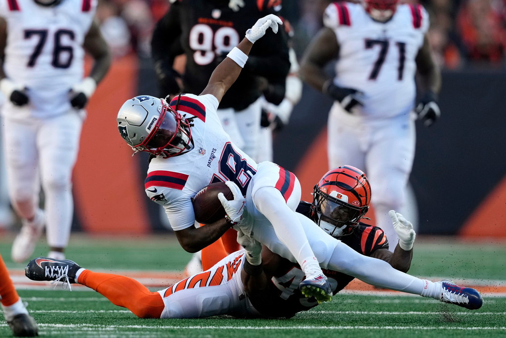 New England Patriots wide receiver Kyle Williams (18) is tackled by Cincinnati Bengals linebacker Barrett Carter during the second half of an NFL football game, Sunday, Nov. 23, 2025, in Cincinnati. (AP Photo/Carolyn Kaster)