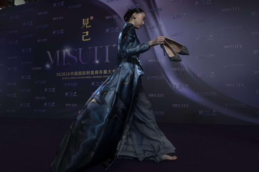 A model removes her high heels as she prepares for the Misuity SS2026 China Fashion Week opening show held on the outskirts of Beijing, China, Friday, Sept. 5, 2025. (AP Photo/Ng Han Guan) A model removes her high heels as she prepares for the Misuity SS2026 China Fashion Week opening show held on the outskirts of Beijing, China, Friday, Sept. 5, 2025. (AP Photo/Ng Han Guan)