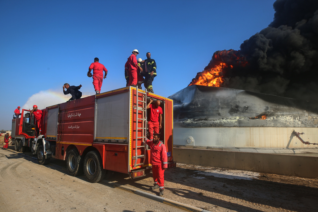 Firefighters work to contain a fire at the Zawiya oil refinery following a drone strike in Zawiya, Libya, Tuesday, Aug. 11, 2026. (AP Photo/Yousef Murad)