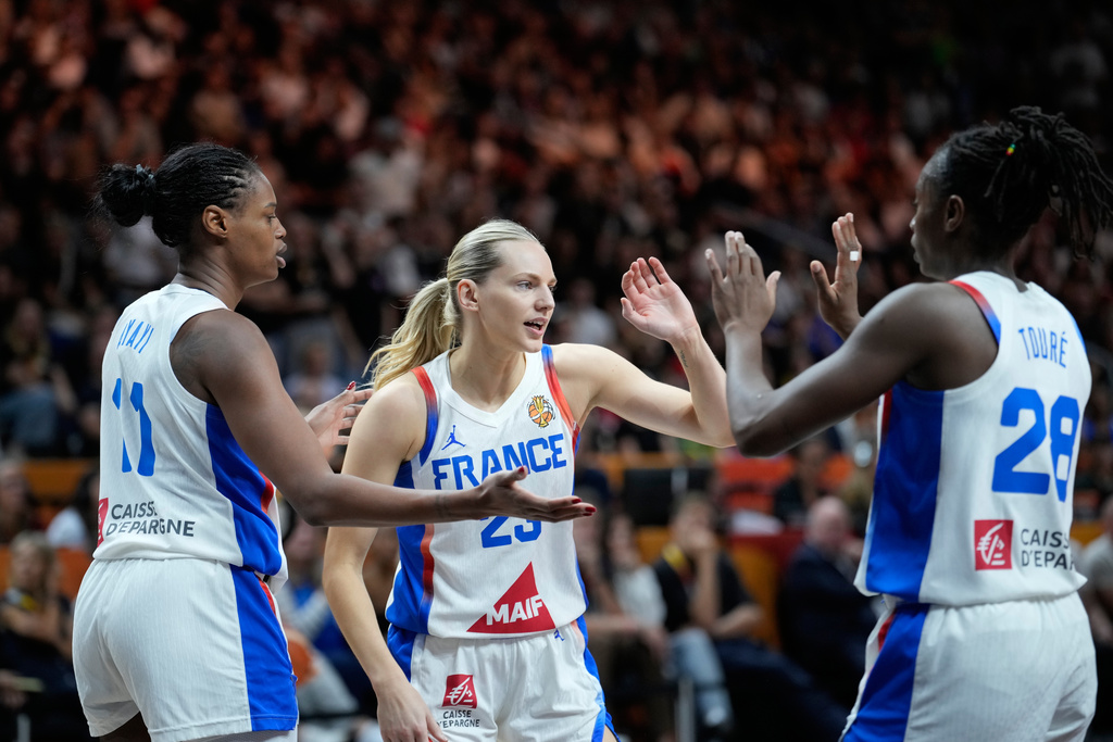France's Valeriane Ayayi, left, Marine Johannes, center, and Mamignan Toure react during the Women's Basketball World Cup semifinal match between France and Germany in Berlin, Saturday, Sept. 12, 2026. (AP Photo/Ebrahim Noroozi)