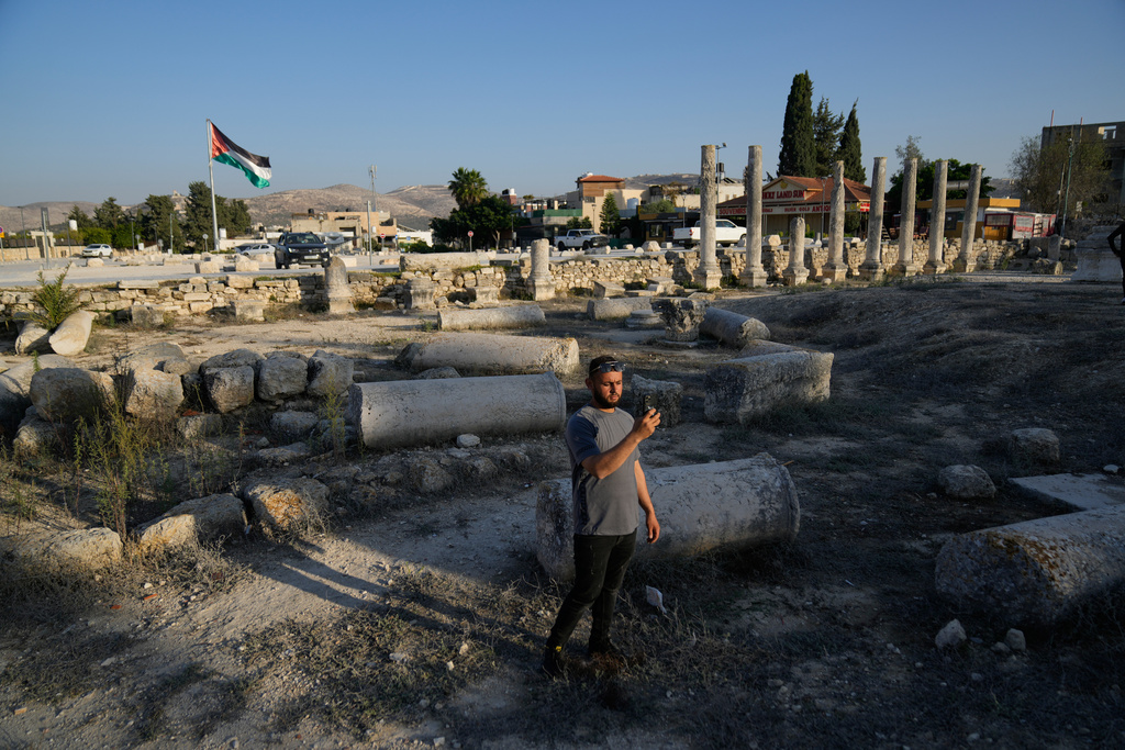 A Palestinian visitor takes a photo at the Roman historical site in the West Bank town of Sebastia Thursday, Nov. 20, 2025. (AP Photo/Nasser Nasser)