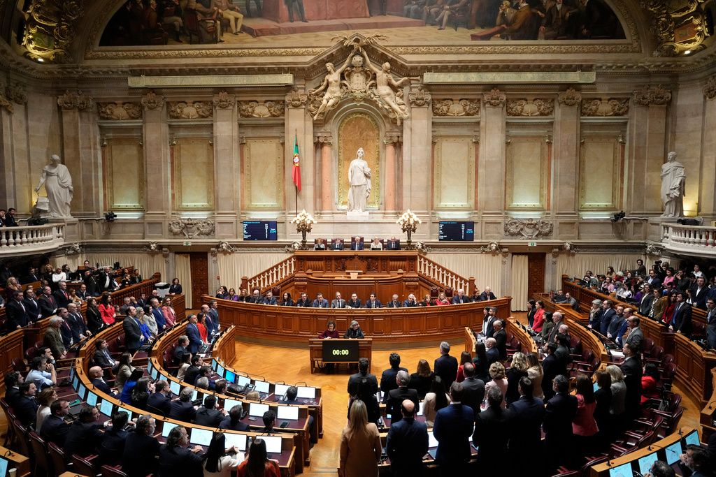 FILE - Members of opposition parties stand to vote against a government confidence motion at the Portuguese parliament in Lisbon, Tuesday, March 11, 2025. (AP Photo/Armando Franca, file)
