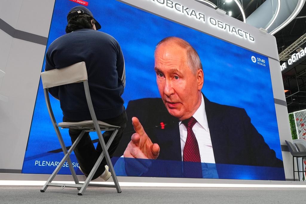 A participant watches a broadcast of Russian President Vladimir Putin's speech on a TV screen during a plenary session of the St. Petersburg International Economic Forum in St. Petersburg, Russia, Friday, June 5, 2026. (AP Photo/Dmitri Lovetsky)