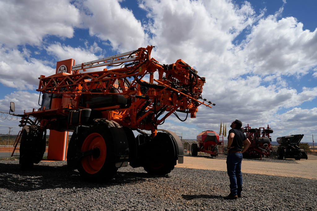 A salesman looks at agricultural machinery displayed at an equipment dealership, representing one of the sectors affected by U.S. tariffs, on the outskirts of Brasilia, Brazil, Wednesday, July 22, 2026. (AP Photo/Eraldo Peres)