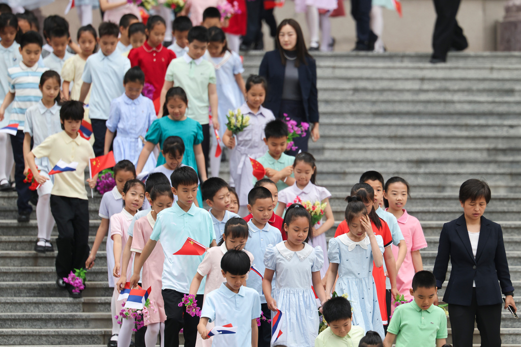 Children holding Russian and Chinese flags walk ahead of a welcoming ceremony for Russian President Vladimir Putin at the Great Hall of the People in Beijing, China Wednesday, May 20, 2026. (Maxim Shemetov/Pool Photo via AP)