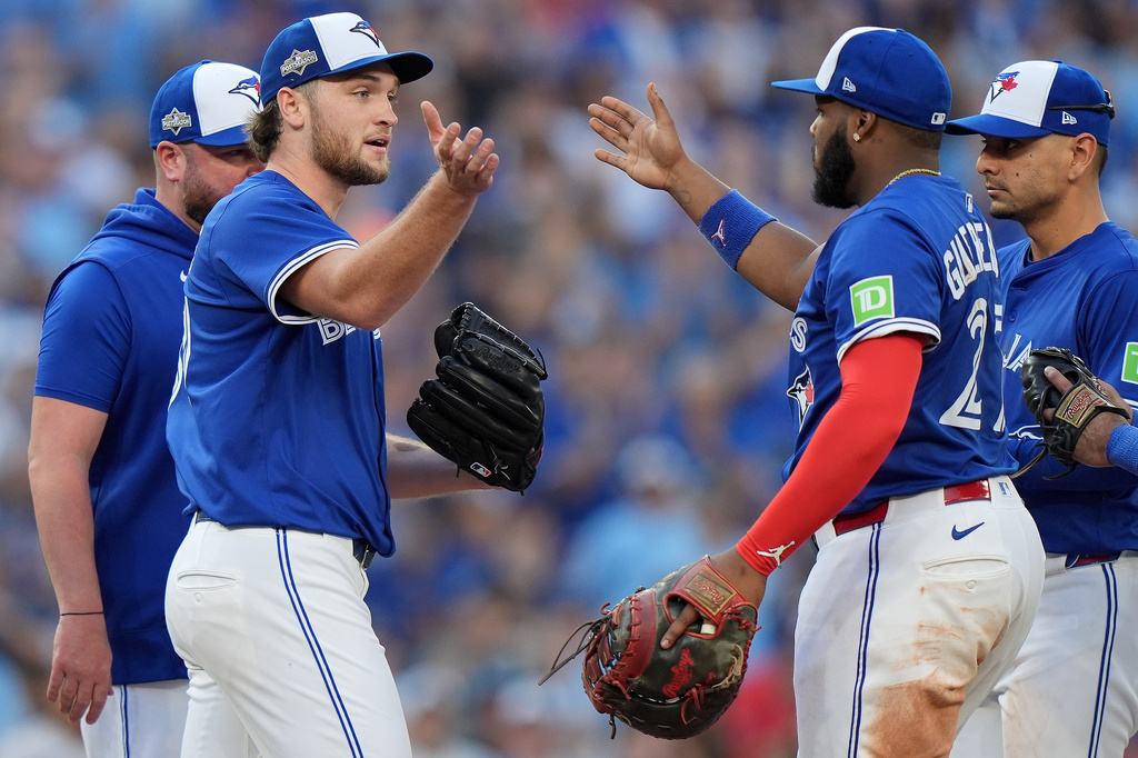 Toronto Blue Jays pitcher Trey Yesavage, front left, celebrates with teammate Vladimir Guerrero Jr., front right, after being pulled from the mound by manager John Schneider, back left, during the sixth inning of Game 2 of baseball's American League Division Series against the New York Yankees in Toronto, Sunday, Oct. 5, 2025. (Frank Gunn/The Canadian Press via AP)