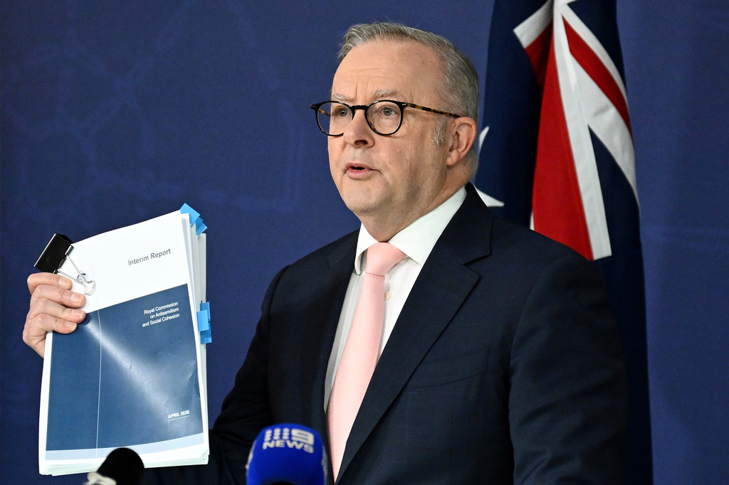 Australian Prime Minister Anthony Albanese holds up the report on Antisemitism and Social Cohesion during a press conference at the Commonwealth Parliamentary Offices in Sydney, Thursday, April 30, 2026. (Dan Himbrechts/AAP Image via AP)