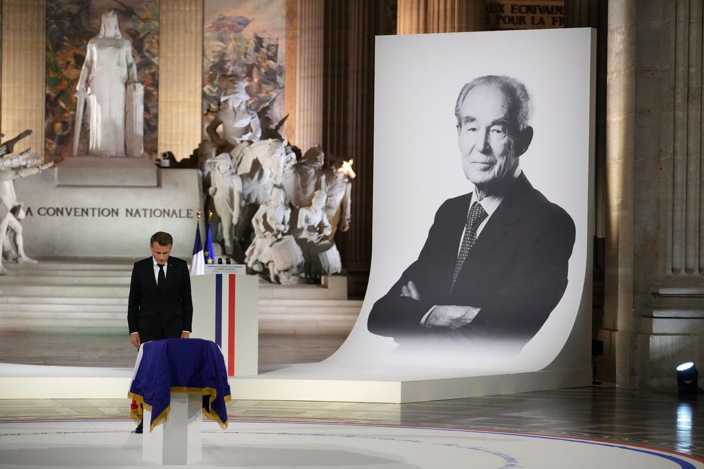 French President Emmanuel Macron pays his respects to late Robert Badinter, a revered rights defender who spearheaded France's drive to end the death penalty, during his indiction ceremony at the Pantheon monument , Thursday, Oct. 9, 2025 in Paris. (AP Photo/Christophe Ena, Pool)
