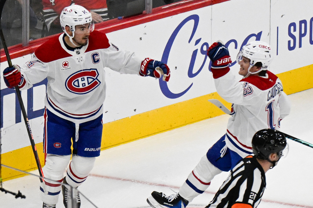 Montreal Canadiens right wing Cole Caufield (13) celebrates with center Nick Suzuki, left, after Caufield scores a goal against the Chicago Blackhawks during the second period of an NHL hockey game Saturday, Oct. 11, 2025, in Chicago. (AP Photo/Matt Marton)
