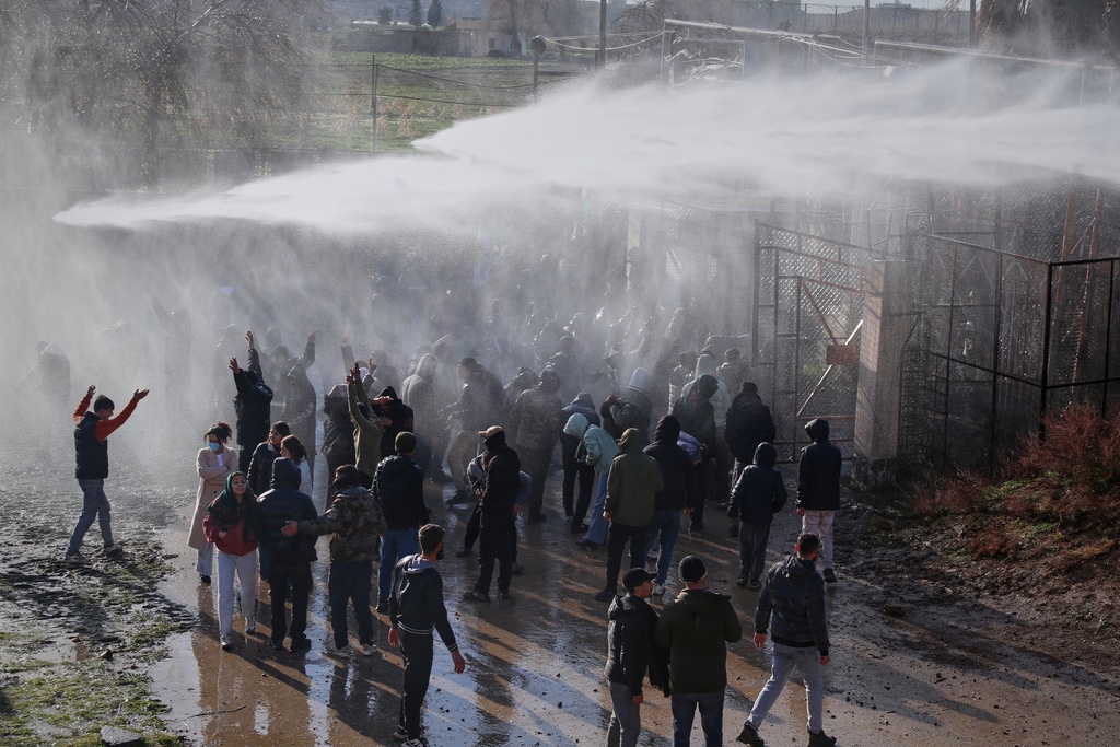 Turkish police use water cannons to prevent Kurdish demonstrators from storming a border crossing as they protest the Syrian government's offensive against Kurdish-led forces and what they perceive as support from Turkey, as seen from Qamishli, northeastern Syria, Jan. 20, 2026. (AP Photo/Baderkhan Ahmad)