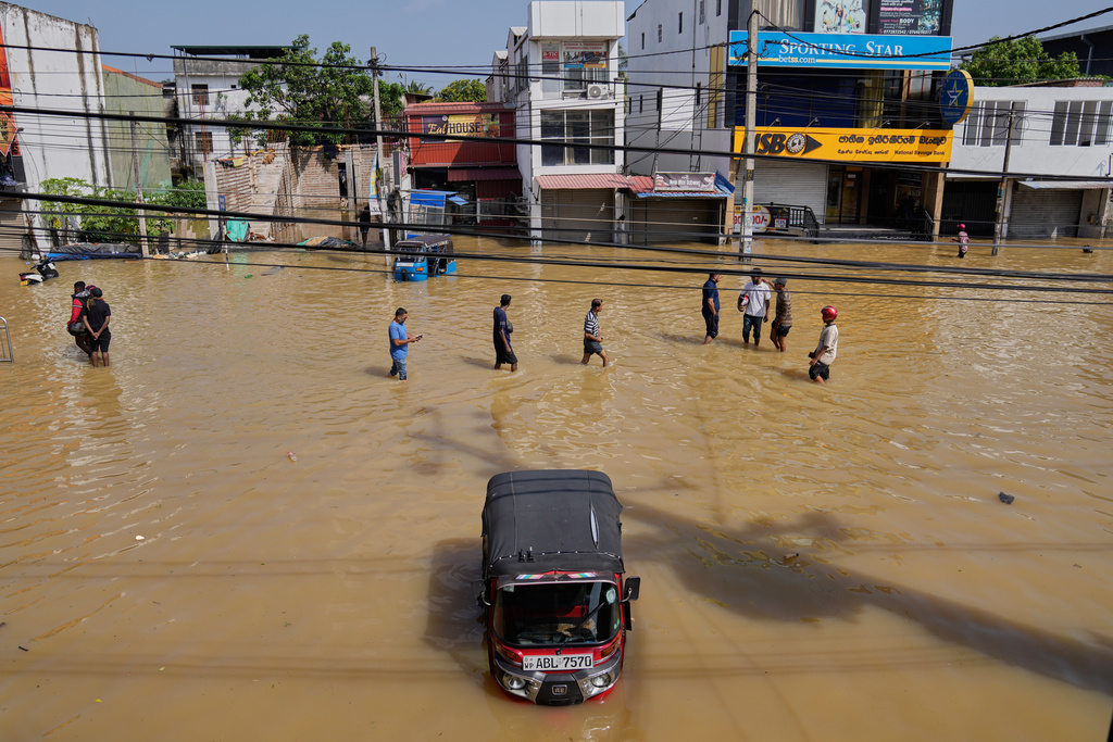 Flood victims wade through a submerged area of Colombo, Sri Lanka, on Sunday, Nov. 30, 2025. (AP Photo/Eranga Jayawardena)