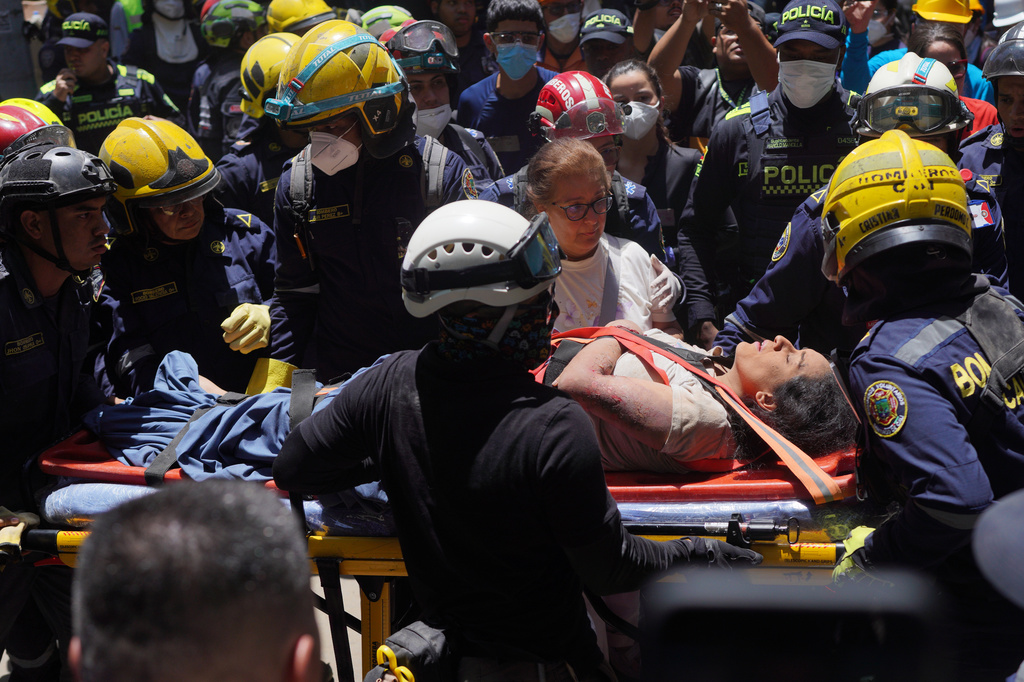 Rescue workers carry Diana Troncoso after pulling her from the rubble the day after an earthquake struck Pereira, Colombia, Tuesday, Aug. 11, 2026. (AP Photo/Ivan Valencia)