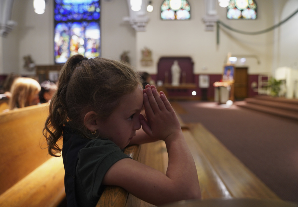 A student at St. John Berchmans' school kneels to pray during Mass at Blessed Carlo Acutis Parish on Wednesday, Sept. 3, 2025, in Chicago. (AP Photo/Jessie Wardarski)