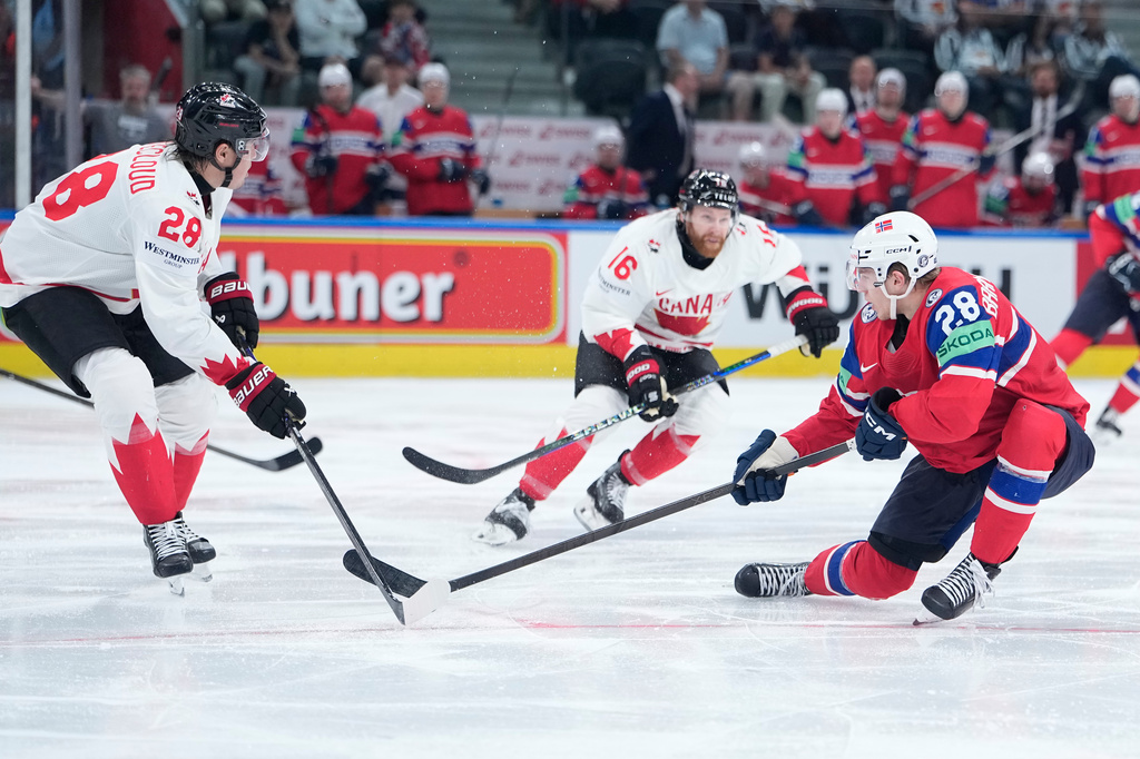 Canada's Zach Whitecloud (28), Canada's Connor Brown (16), Norway's Michael Brandsegg-Nygard (28) challenge for the puck during the 2026 IIHF Men's Ice Hockey World Championship bronze medal match between Canada and Norway, in Zurich, Switzerland, Sunday, May 31, 2026. (AP Photo/Darko Bandic)