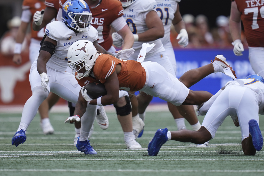 Texas running back Christian Clark, center, dives for years against San Jose State during the second half of an NCAA college football game in Austin, Texas, Saturday, Sept. 6, 2025. (AP Photo/Eric Gay)