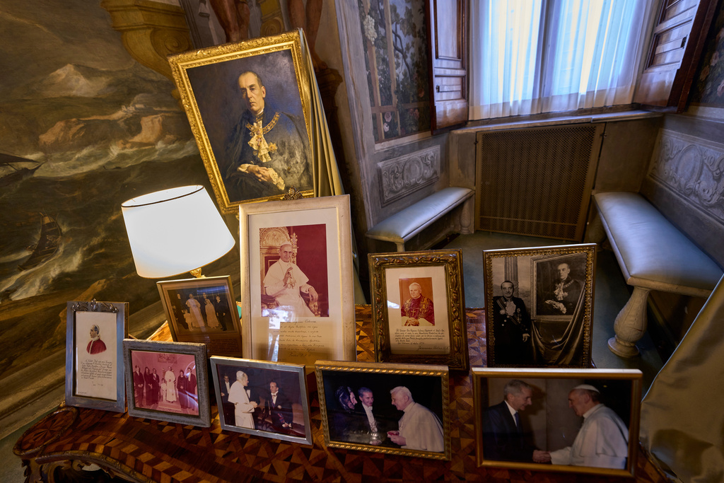 A portrait of Prince Marcantonio Colonna is seen over family photographs inside the prince's apartments at Palazzo Colonna, or the Colonna Palace, in Rome during a media tour, Friday, Nov. 7, 2025. (AP Photo/Domenico Stinellis)