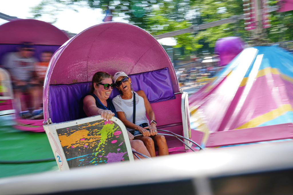 Valerie Nelson, left, and Sherri Gray ride the Tilt-A-Whirl, Thursday, Aug. 27, 2026, at the Minnesota State Fair in Falcon Heights, Minn. (AP Photo/Ellen Schmidt)