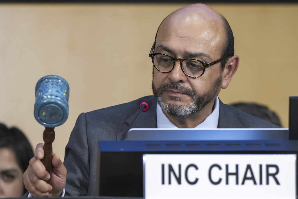 Luis Vayas Valdivieso, the chair of the negotiating committee, bangs a gavel made of recycled plastic bottle tops from a Nairobi landfill, during a plenary session of the second part of the fifth session of the Intergovernmental Negotiating Committee on Plastic Pollution, at the European headquarters of the United Nations in Geneva, Switzerland, Thursday, Aug. 14, 2025. (Martial Trezzini/Keystone via AP)