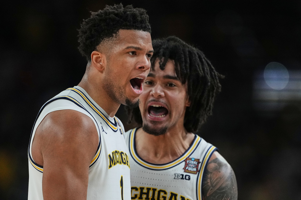 Michigan's Trey McKenney, left, and Elliot Cadeau celebrate during the second half of the NCAA college basketball tournament national championship game against UConn at the Final Four, Monday, April 6, 2026, in Indianapolis. (AP Photo/Michael Conroy)