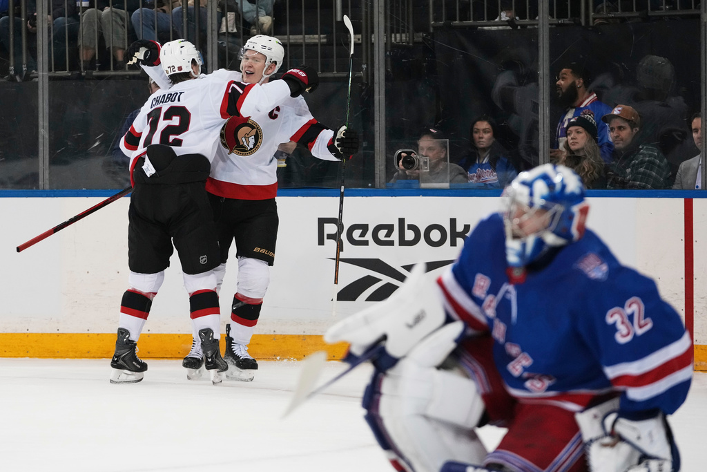 Ottawa Senators' Brady Tkachuk, center, celebrates with teammate Thomas Chabot, left, after scoring a goal as New York Rangers goaltender Jonathan Quick (32) looks away during the first period of an NHL hockey game Wednesday, Jan. 14, 2026, in New York. (AP Photo/Frank Franklin II)