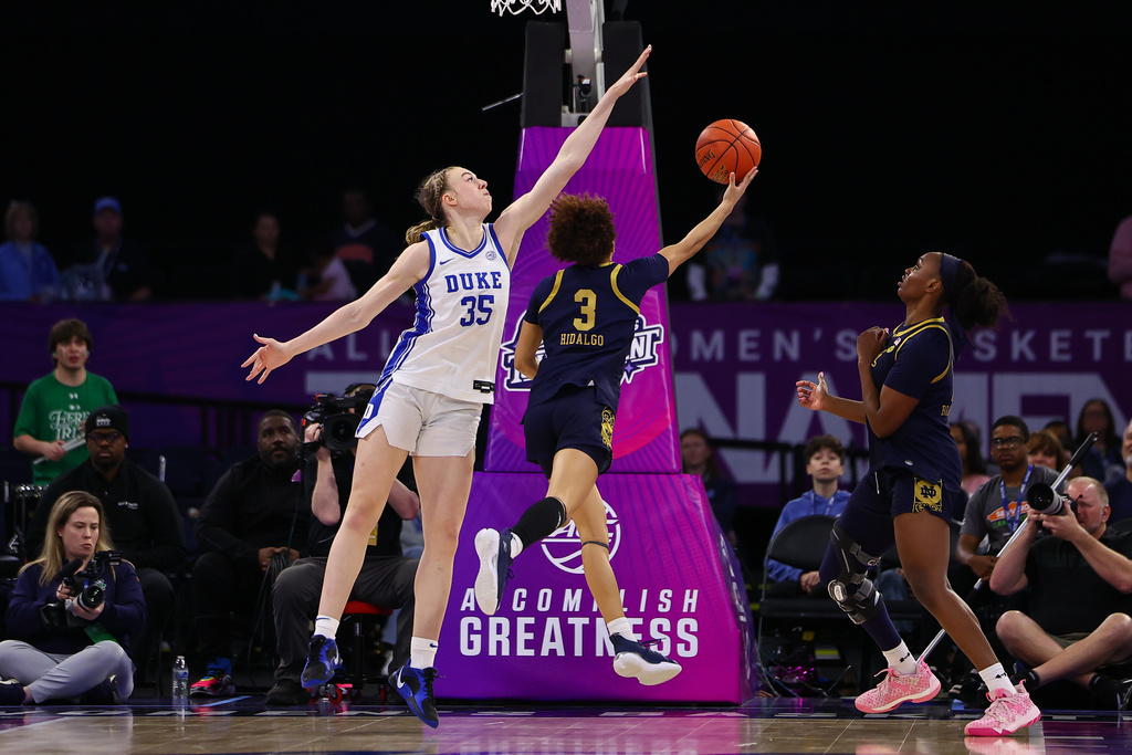 Notre Dame guard Hannah Hidalgo (3) shoots under Duke forward Toby Fournier (35) during the second half of an NCAA college basketball game in the semifinals of the Atlantic Coast Conference tournament, Saturday, March 7, 2026, in Duluth, Ga. (AP Photo/Colin Hubbard)