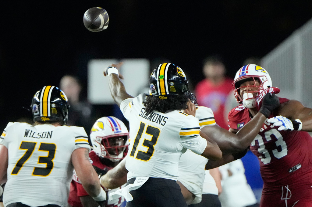 Missouri quarterback Austin Simmons (13) throws for a touchdown during the first half of an NCAA college football game against Kansas, Friday, Sept. 11, 2026, in Lawrence, Kan. (AP Photo/Charlie Riedel)