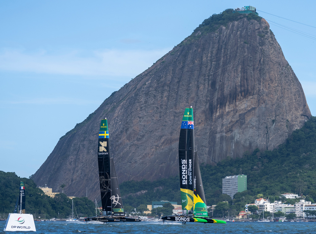 In this photo provided by SailGP, BONDS Flying Roos SailGP Team, driven by Tom Slingsby, competes ahead of Artemis SailGP Team, driven by Nathan Outteridge, past Sugarloaf Mountain on Race Day 2 of the ENEL Rio Sail Grand Prix in Rio de Janeiro, Brazil, Sunday, April 12, 2026. ( Jason Ludlow/SailGP via AP)