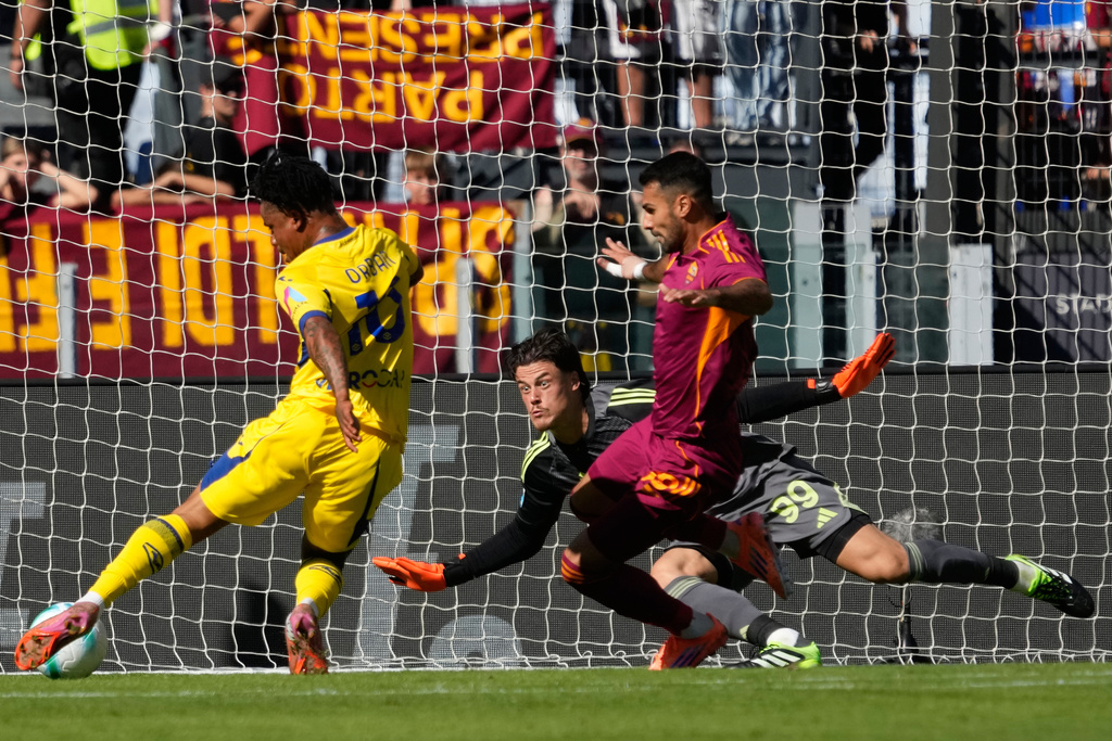 Roma's goalkeeper Mile Svilar, center, saves a shot by Verona's Gift Orban during the Serie A soccer match between Roma and Verona at Rome's Olympic Stadium, Sunday, Sept. 28, 2025. (AP Photo/Gregorio Borgia)
