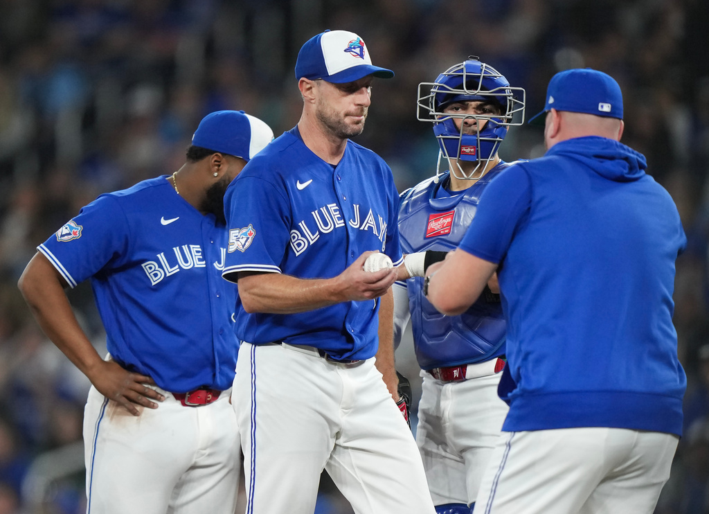 Toronto Blue Jays pitcher Max Scherzer, second from left, is pulled by manager John Schneider, right, during third-inning baseball game action against the Minnesota Twins in Toronto, Sunday, April 12, 2026. (Nathan Denette/The Canadian Press via AP)